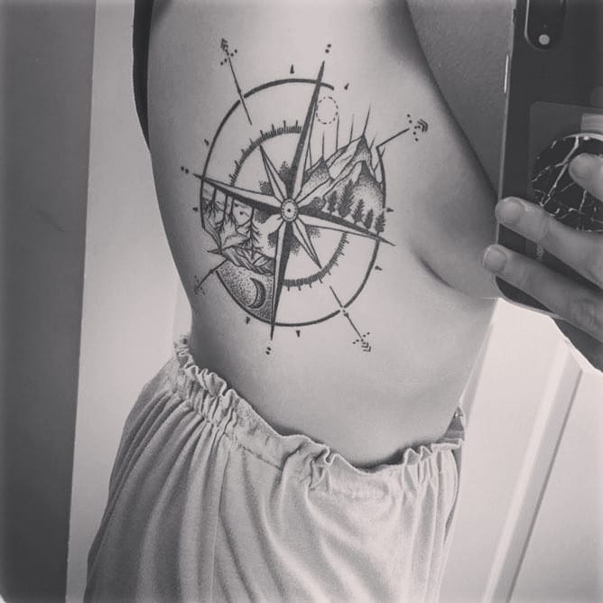 Black Compass tattoo with nature on the ribs