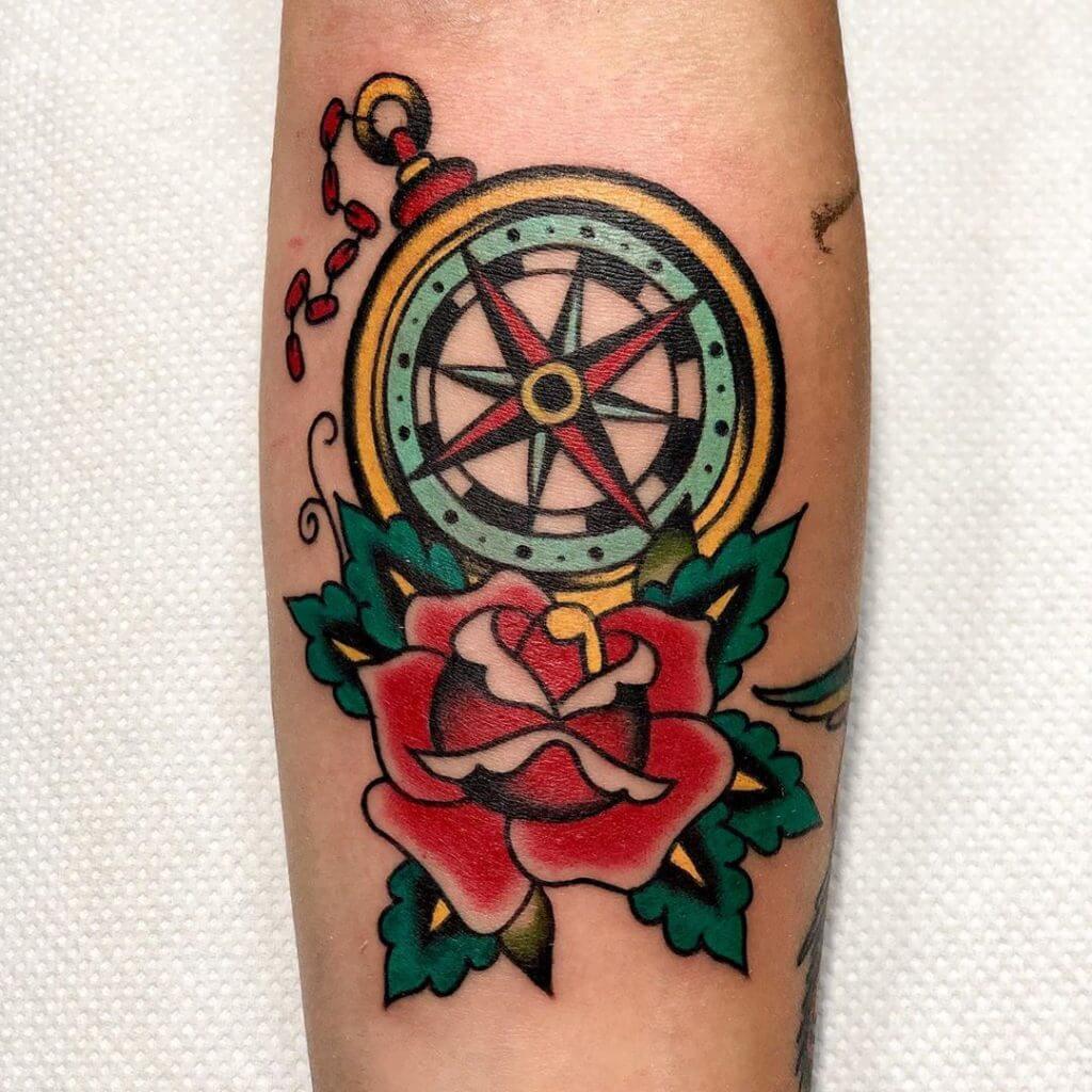 Color Compass tattoo with a rose on the forearm
