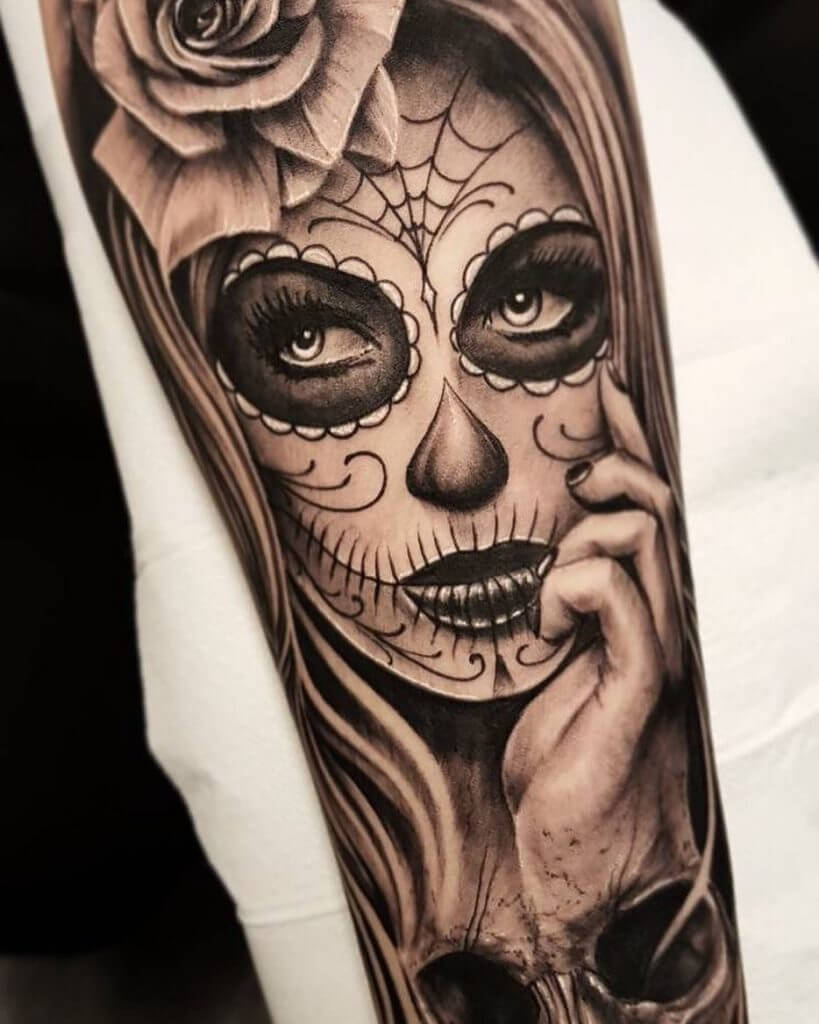 Black and gray forearm tattoo of a female masked face