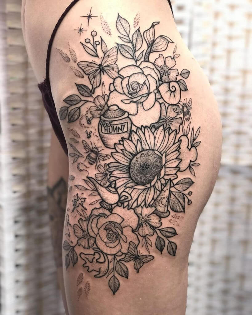 Black Female tattoo of flowers, butterflies, a bee and a honey pot on the left leg