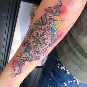 Watercolor Compass tattoo on the right forearm