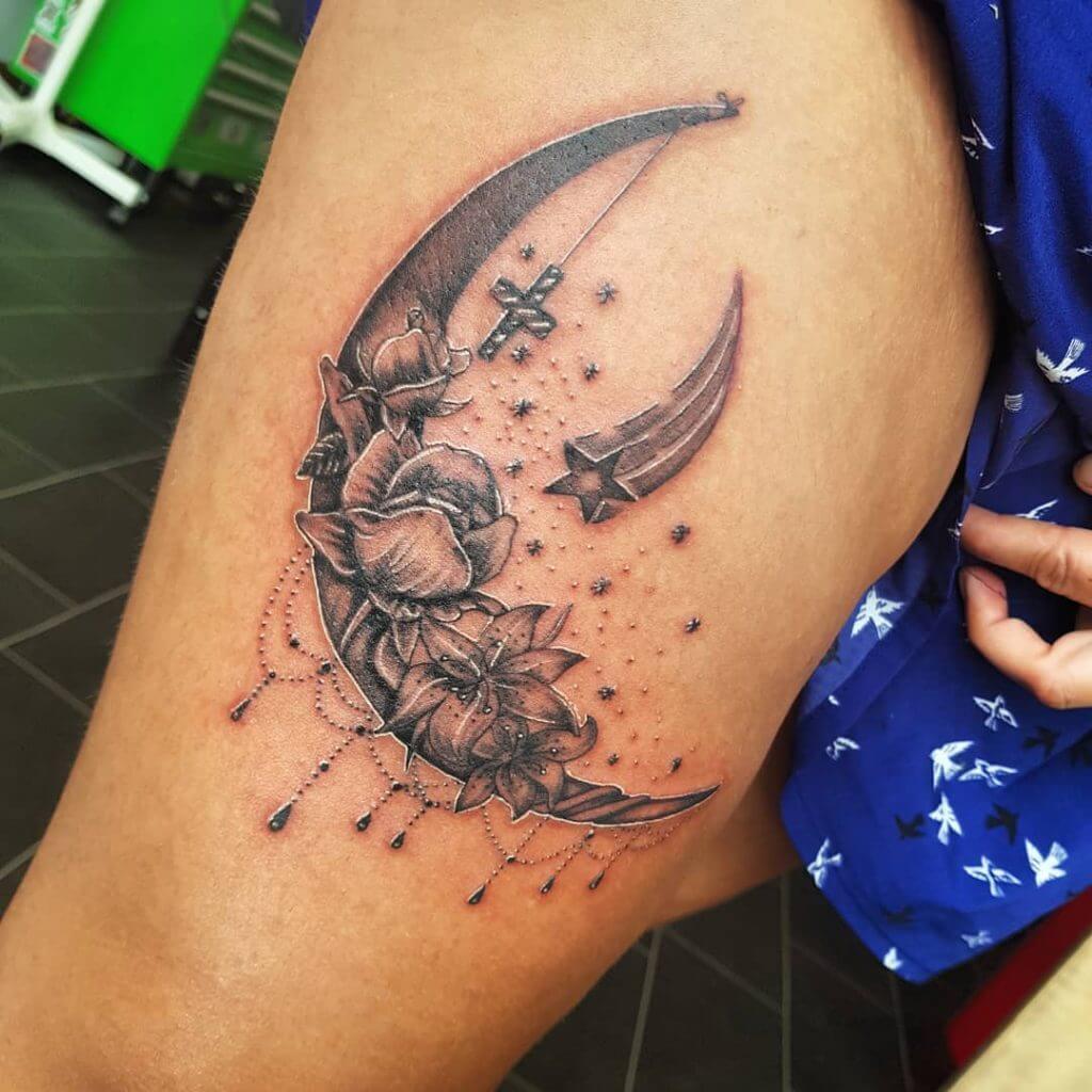 Black and Gray Stars tattoo with a moon and flowers on the thigh
