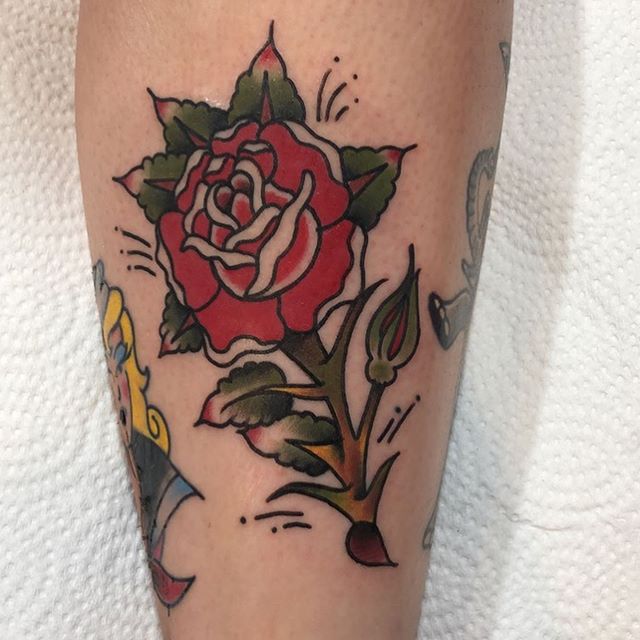 Traditional tattoo of a red rose on the calf