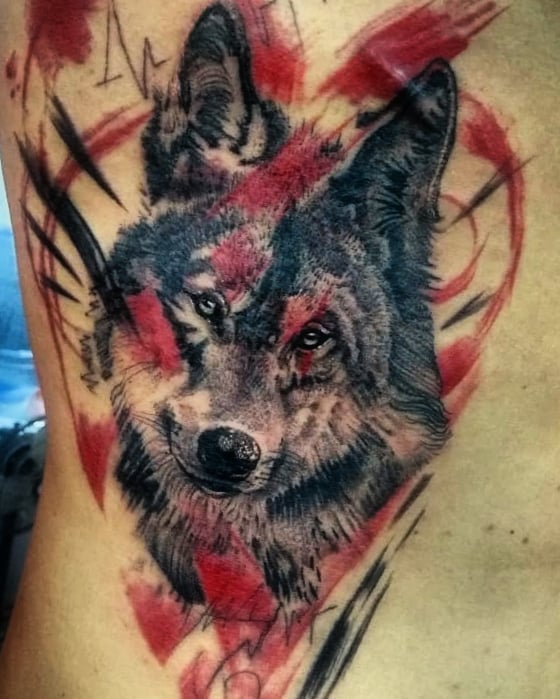 Trash polka tattoo of a wolf head on the ribs