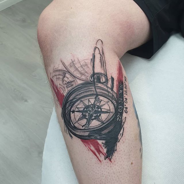 Trash polka tattoo of a compass on the right leg