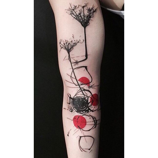 Trash polka tattoo of circles and a flowers on the right arm