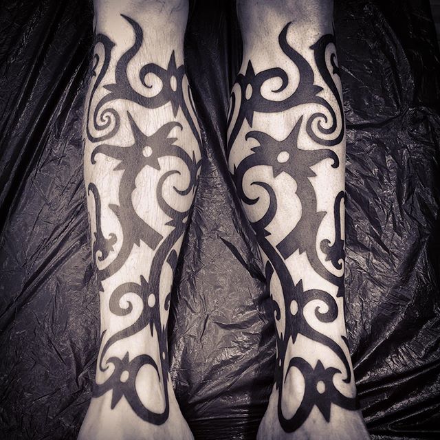 Tribal tattoo on both legs