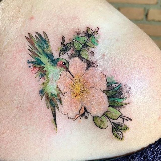 Watercolor tattoo of a flower and a hummingbird on the left shoulder