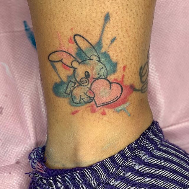 Watercolor tattoo of a bunny with a heart on the right feet