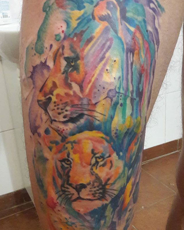 Watercolor tattoo of tiger heads on the right leg