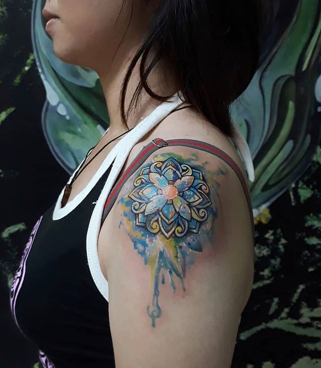 Watercolor tattoo of a mandala tattoo on the left shoulder