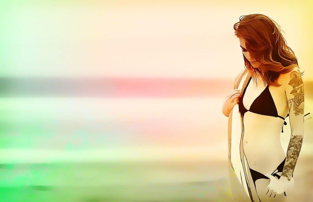 Women on the beach with a color tattoo on the whole left hand