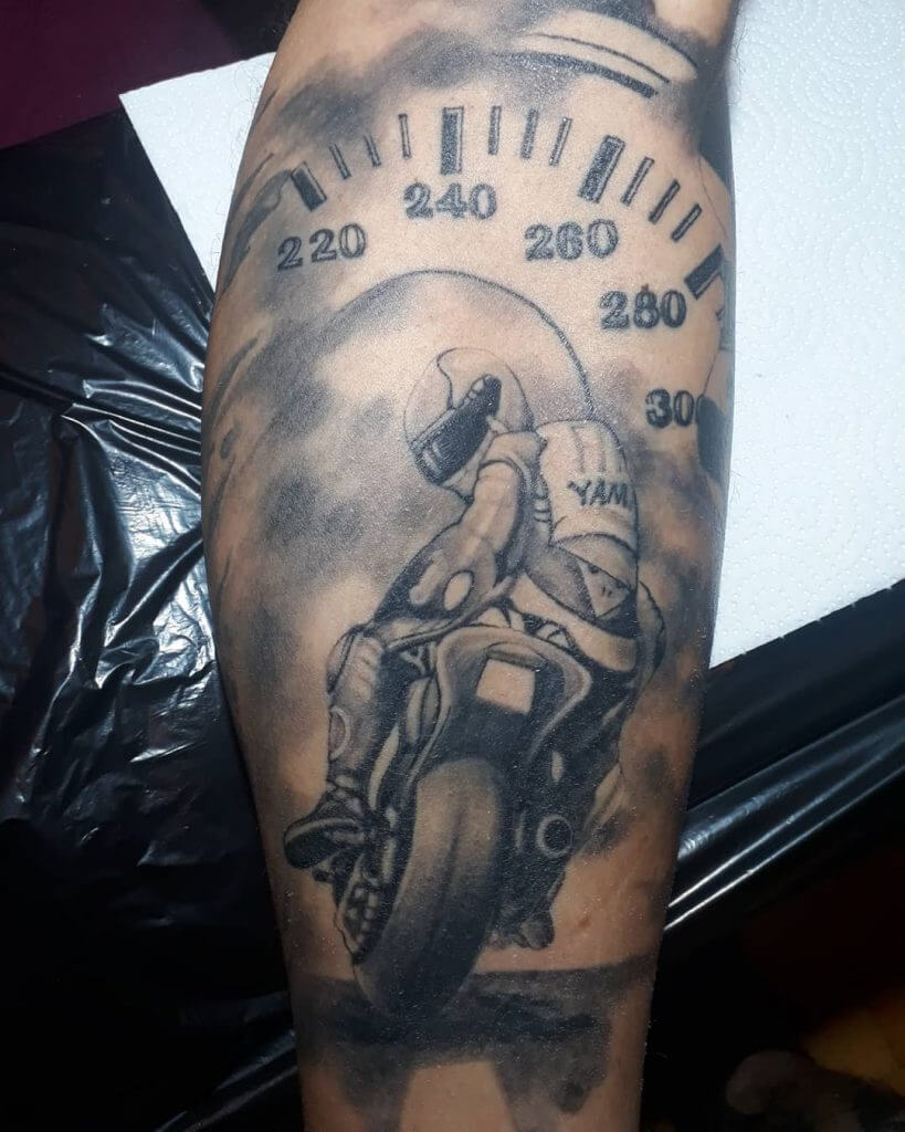 Mens motorbike tattoo of a biker and a speedometer, on the calf
