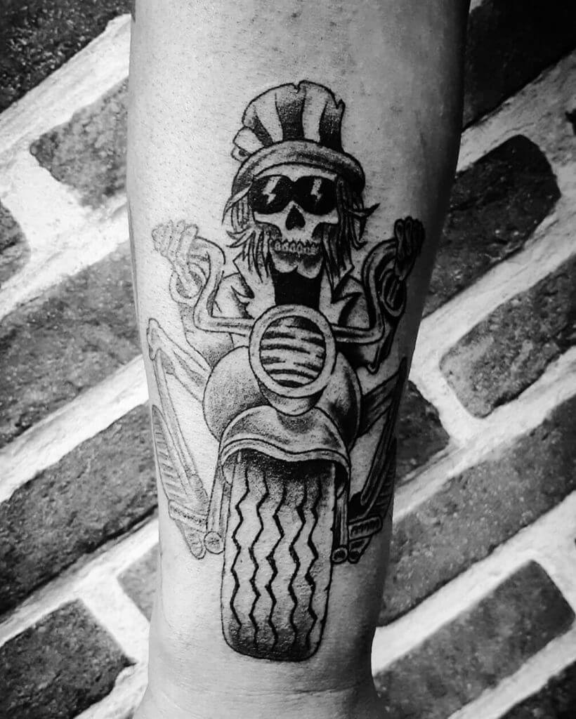 Mens motorbike tattoo of a skeleton on the bike on the right forearm