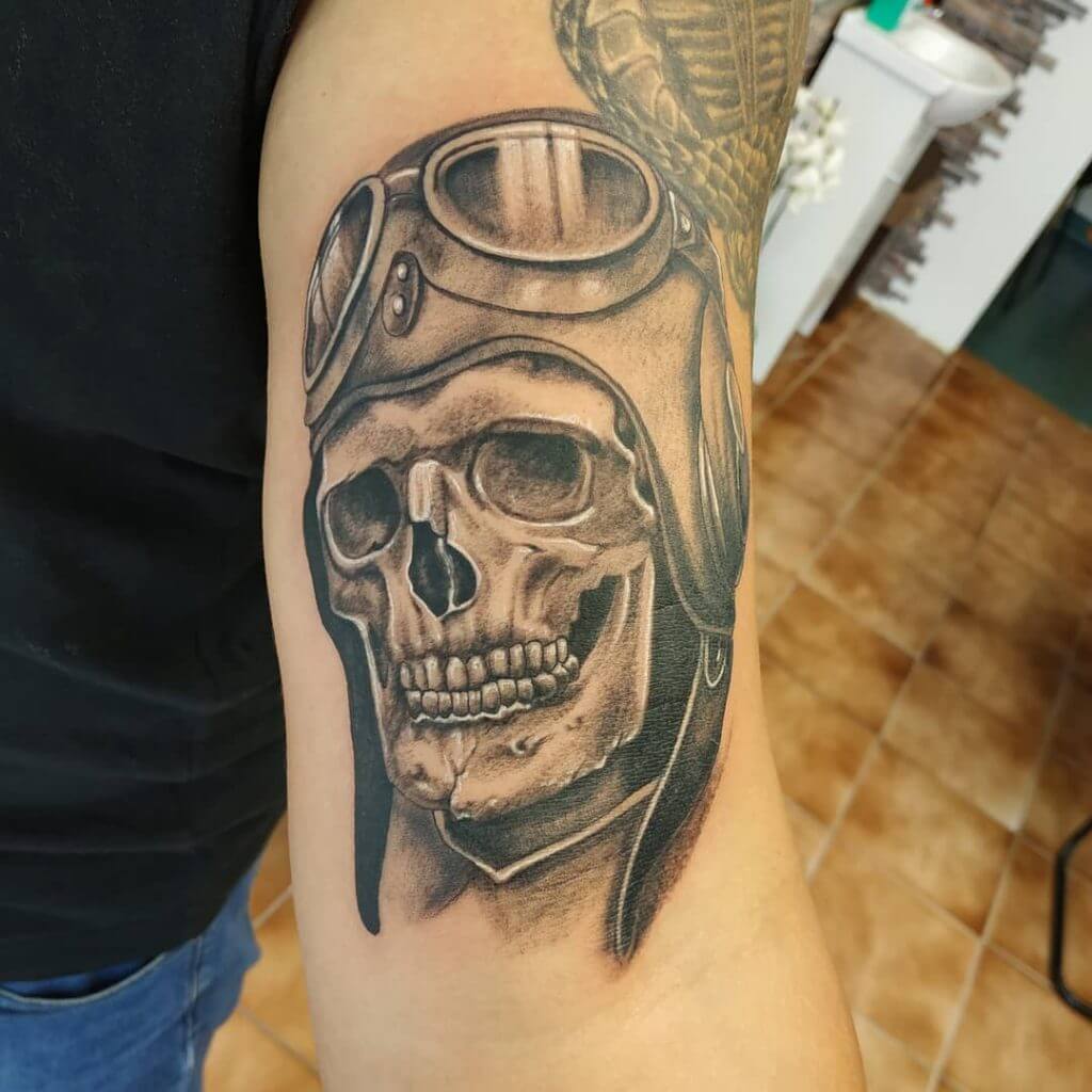 Mens motorbike tattoo of a skull with a helmet on the right arm