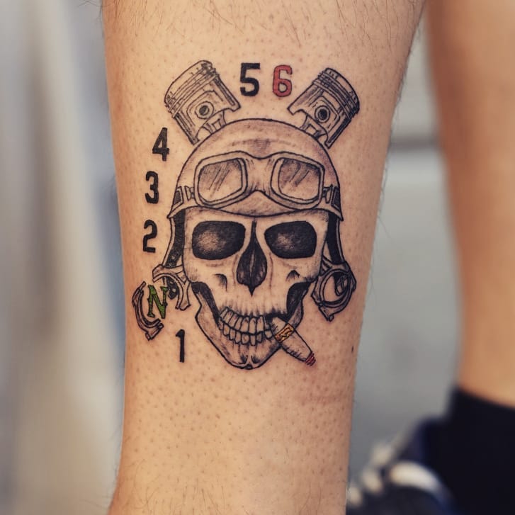 Mens motorbike tattoo of a skull with a helmet and pistons on the right forearm