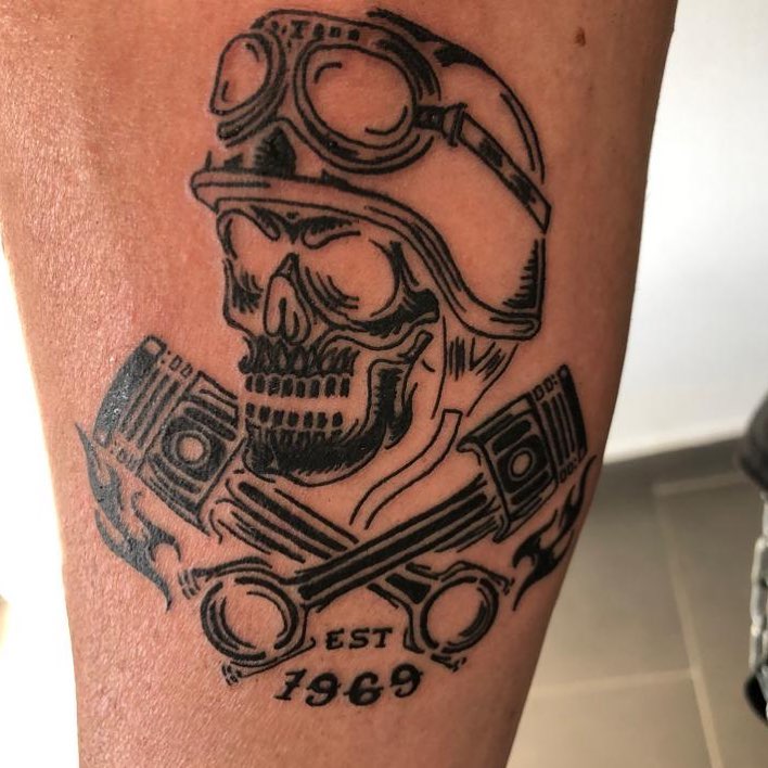 Mens motorbike tattoo of a skull and pistons on the right forearm