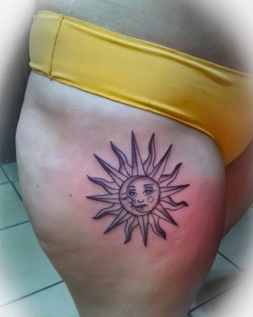 Black Sun tattoo with a moon on right thigh