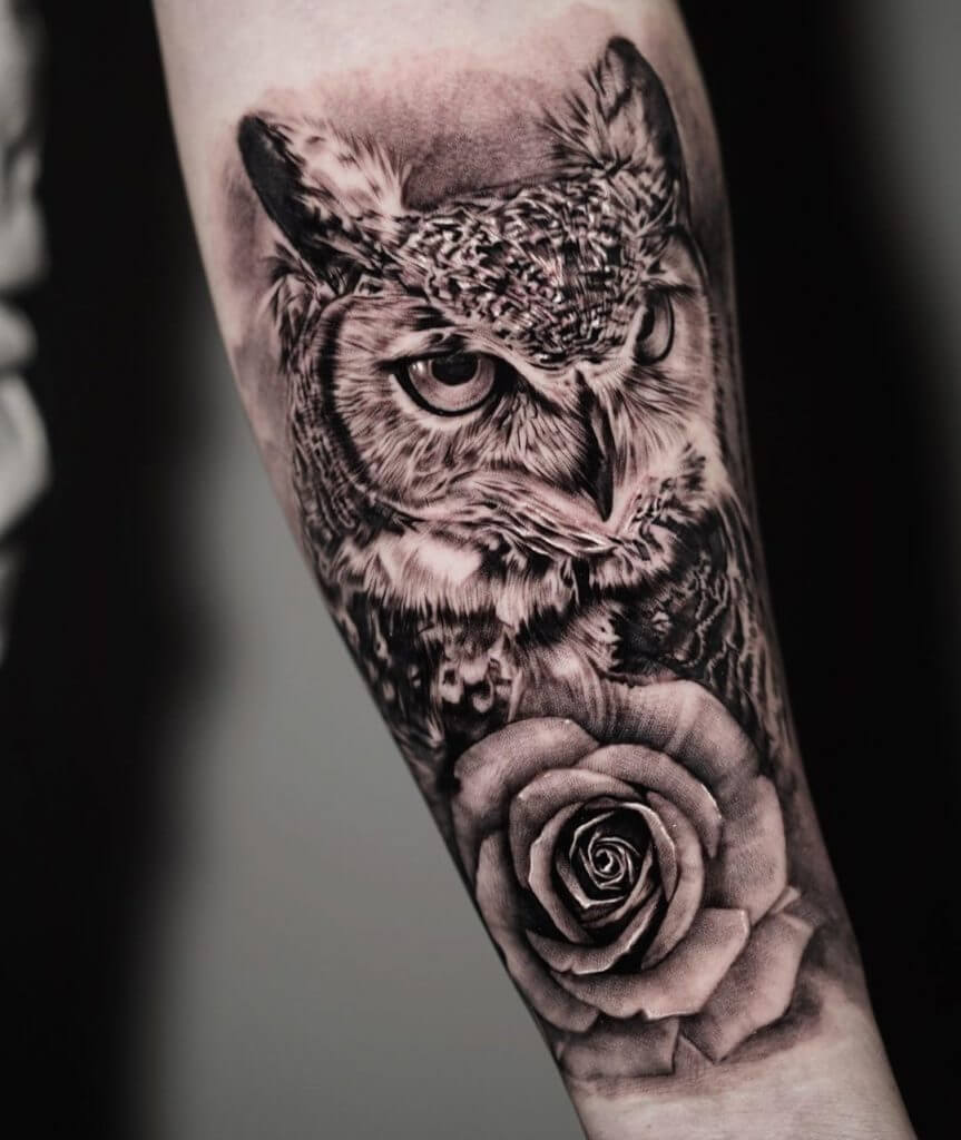 Black and Gray Animal tattoo of an owl and a rose on the left forearm