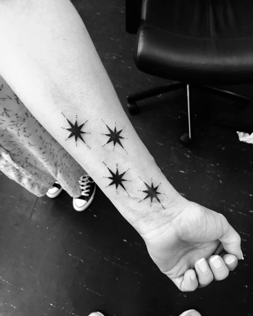 Black female tattoo of stars on the forearm