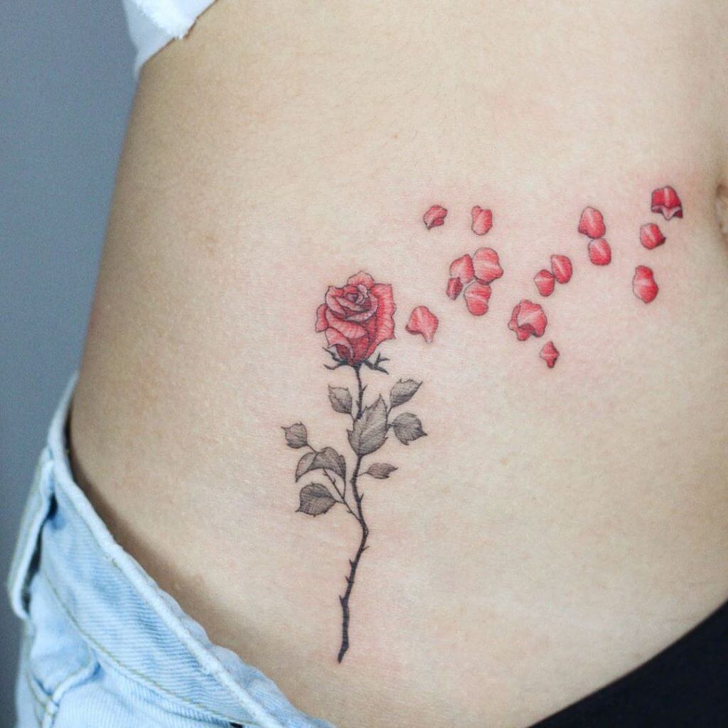Color female tattoo of a rose above the hip