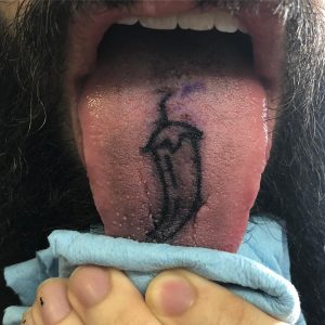 Tongue tattoo of a chilly paper