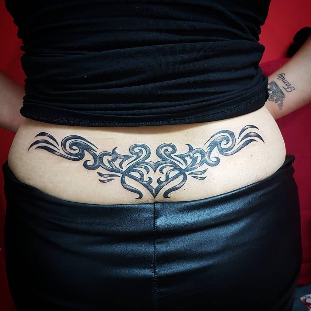 Womans abstract tattoo on the lower back