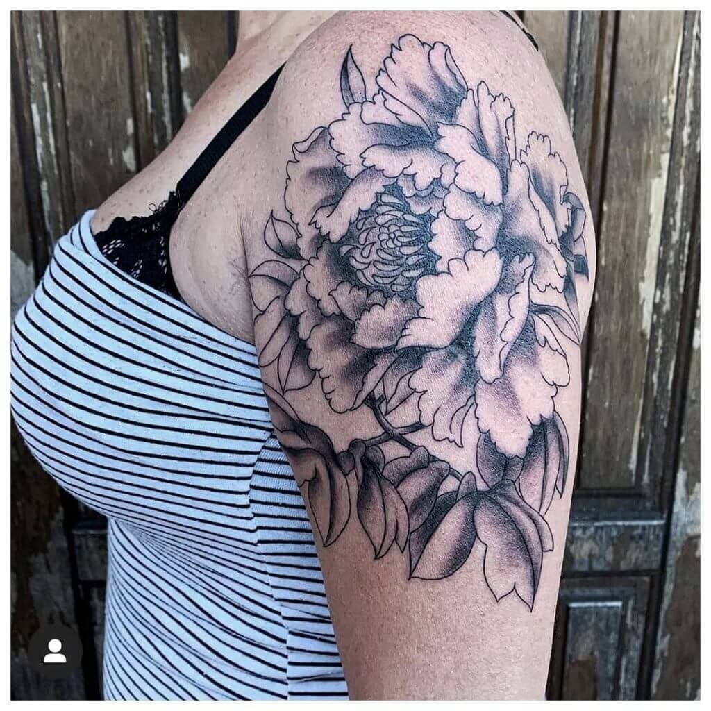 Neo traditional black tattoo for woman of a flower on left shoulder
