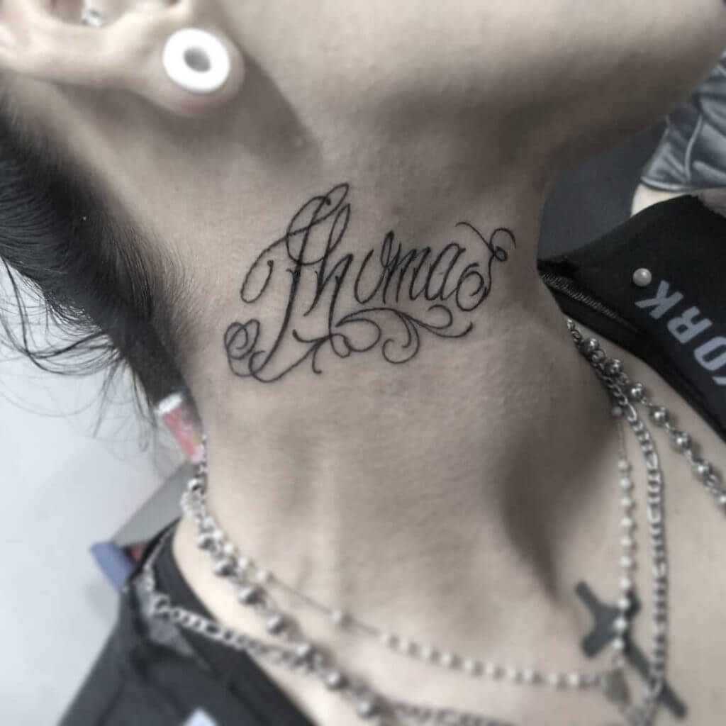Lettering black tattoo for women with name "Thomas" written on the neck