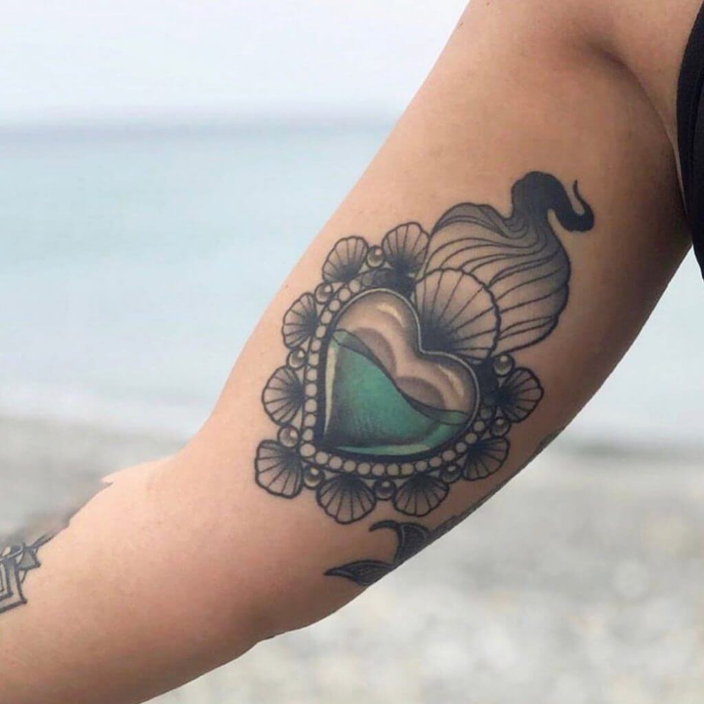 Neo traditional color tattoo for woman of a heart on the right arm