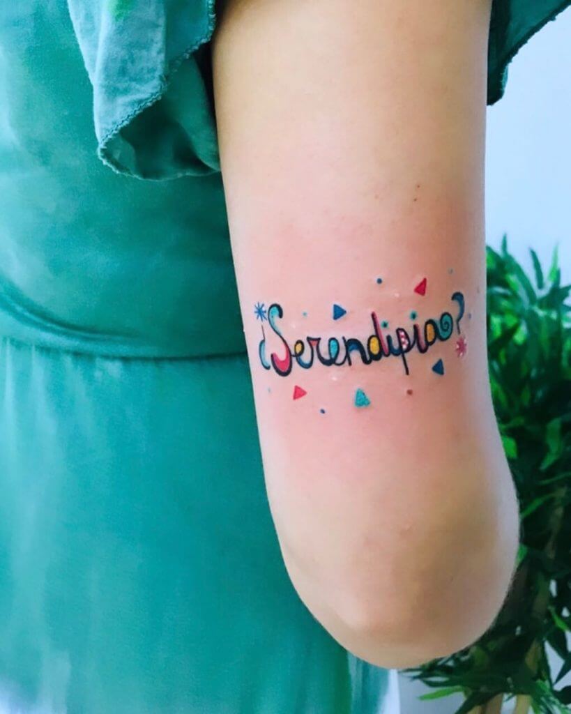 Lettering color tattoo for women with Serendipia written on the right arm