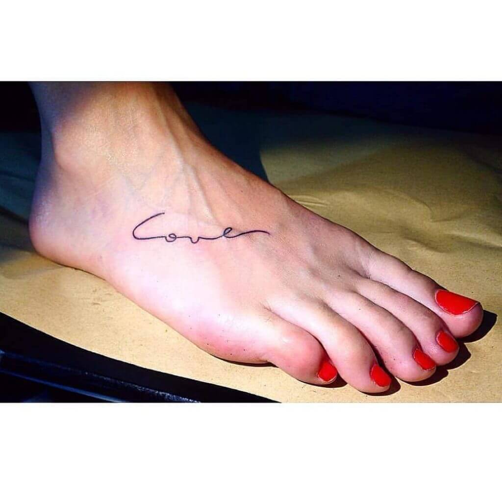 Lettering tattoo for women with "Love" written on the foot