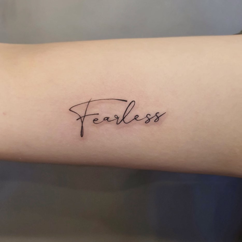 Lettering tattoo for women with "Fearless" written on the forearm