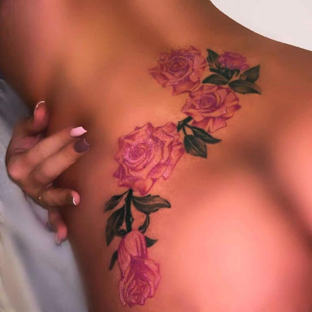 Color womans tattoo of roses on the lower back