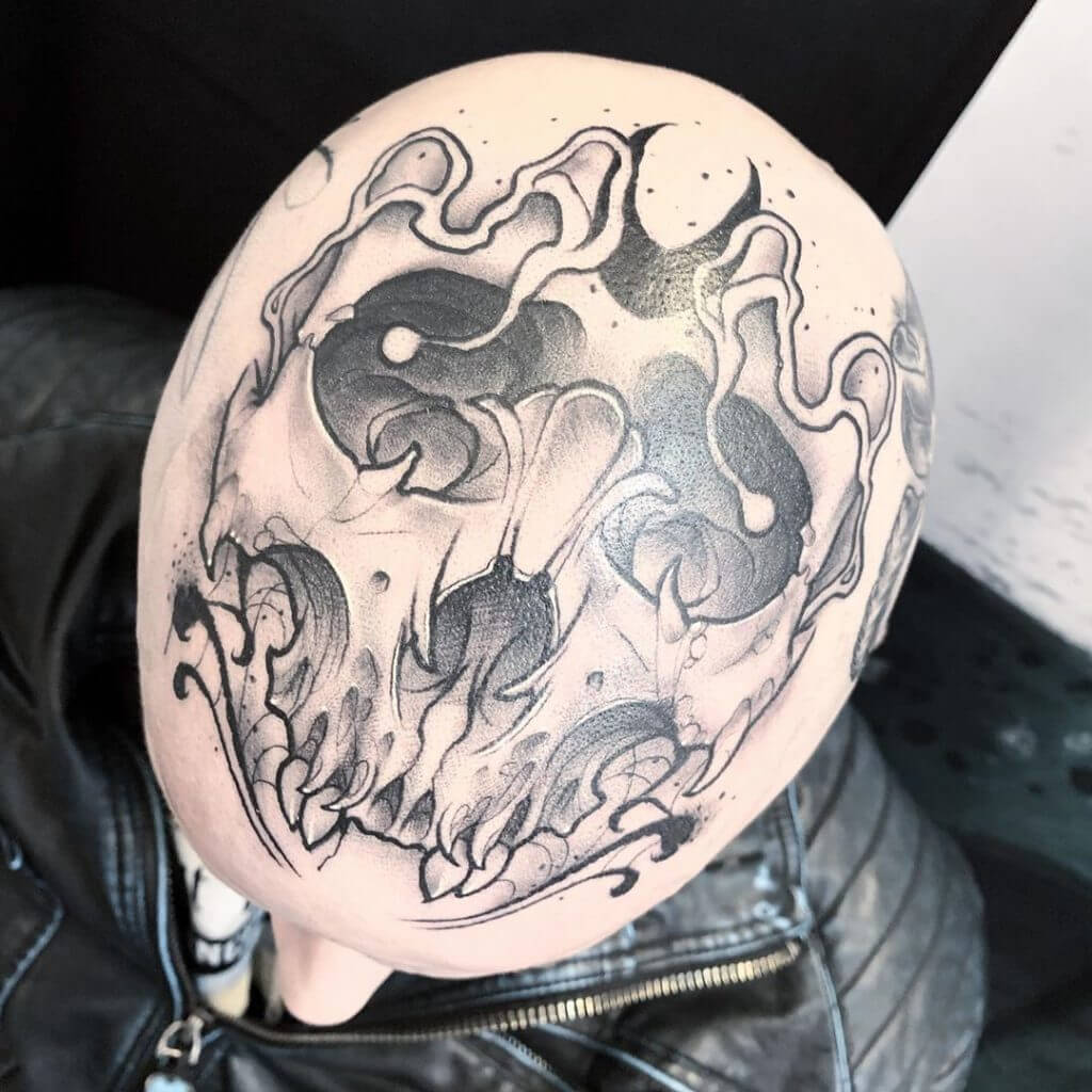 Black neotraditional tattoo of a skull on the head