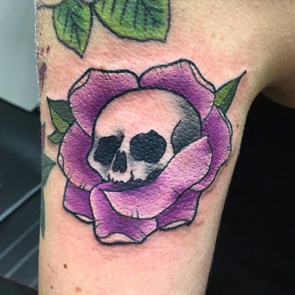 Color neotraditional tattoo with a skull in the flower on the right arm