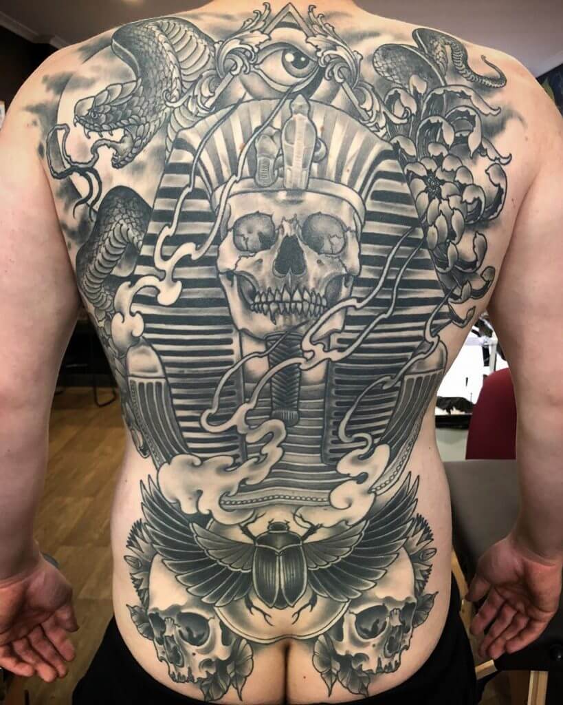 Black neotraditional tattoo with Tutanchamon skull and two another skulls on the back