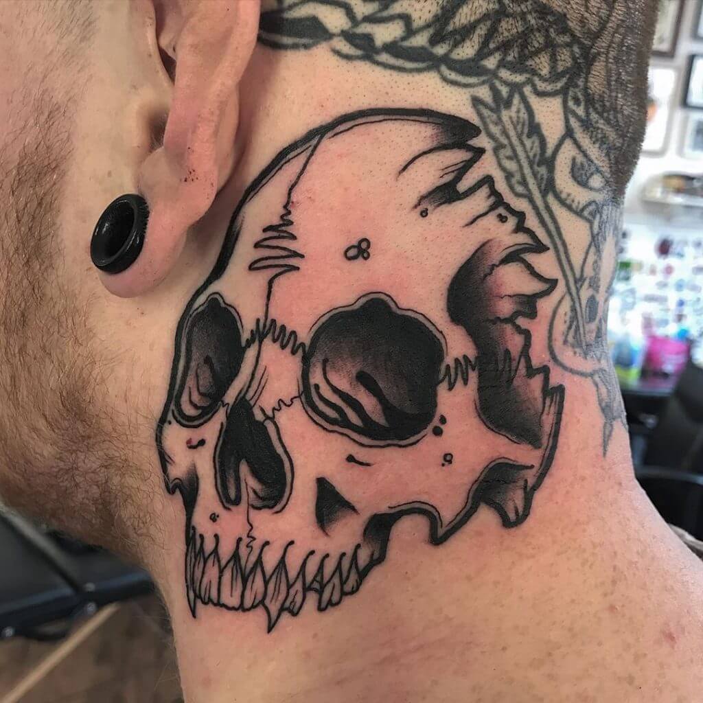 Black neotraditional tattoo with a skull on the neck