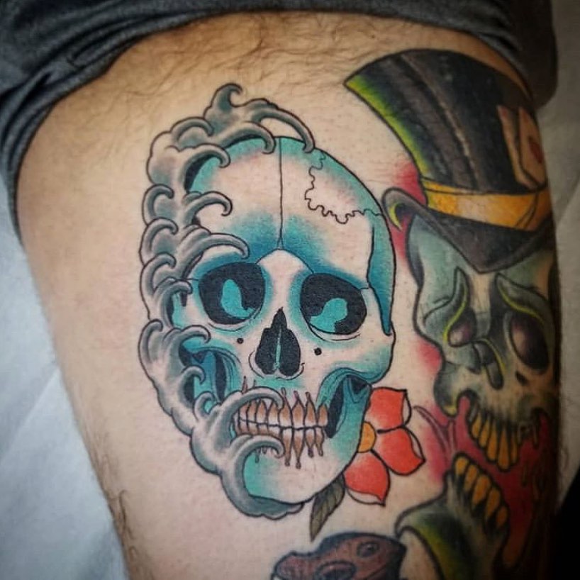 Color neotraditional tattoo with skulls, on the left thigh