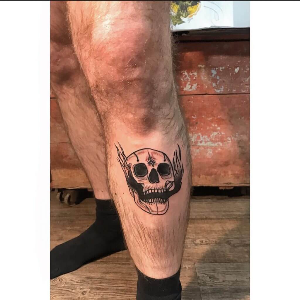 Black neotraditional tattoo of a skull on the left leg
