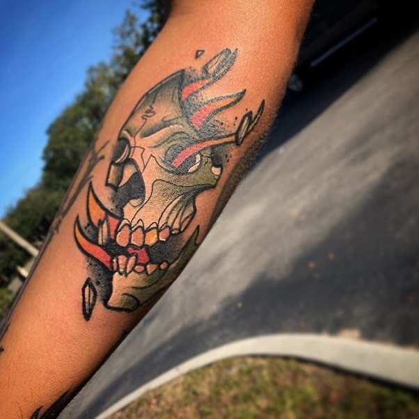Color neo traditional tattoo of a skull on the flames on the forearm