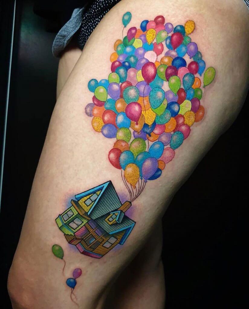 Women color cartoon tattoo of the house from UP on the left thigh