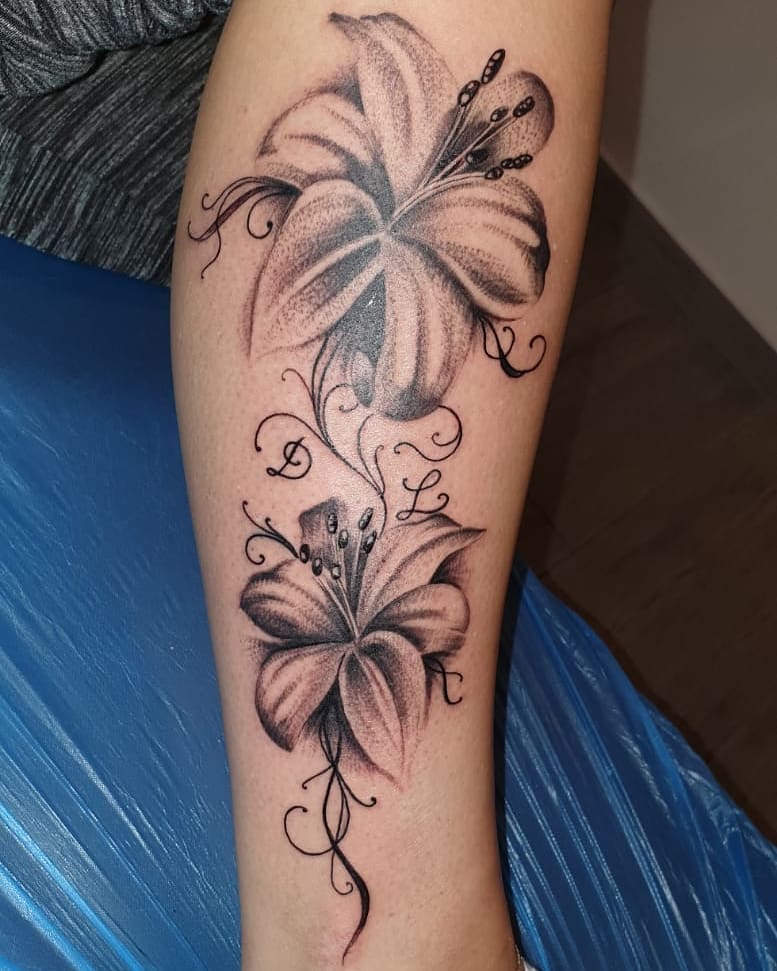 Women black and gray dotwork tattoo of a hibiscus flowers on the calf