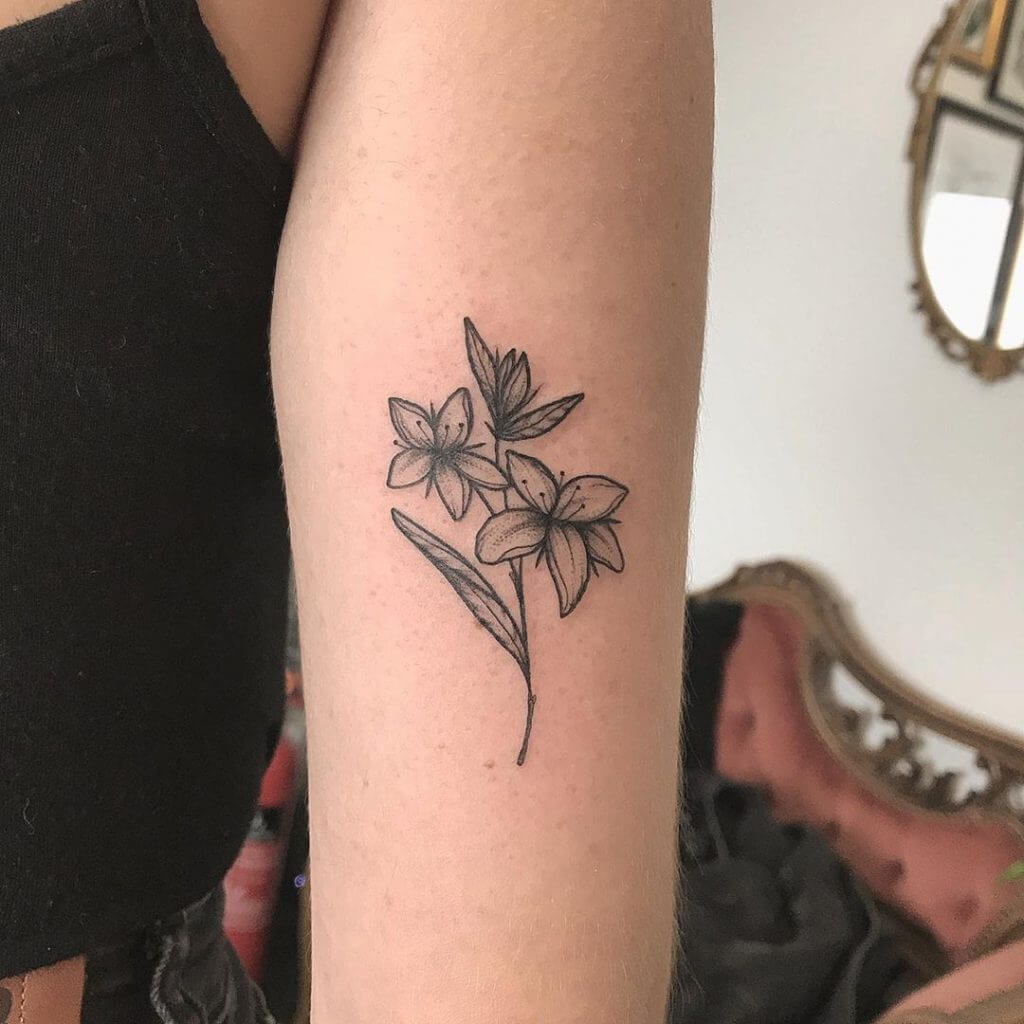 Women black dotwork tattoo of a flowes on the left forearm