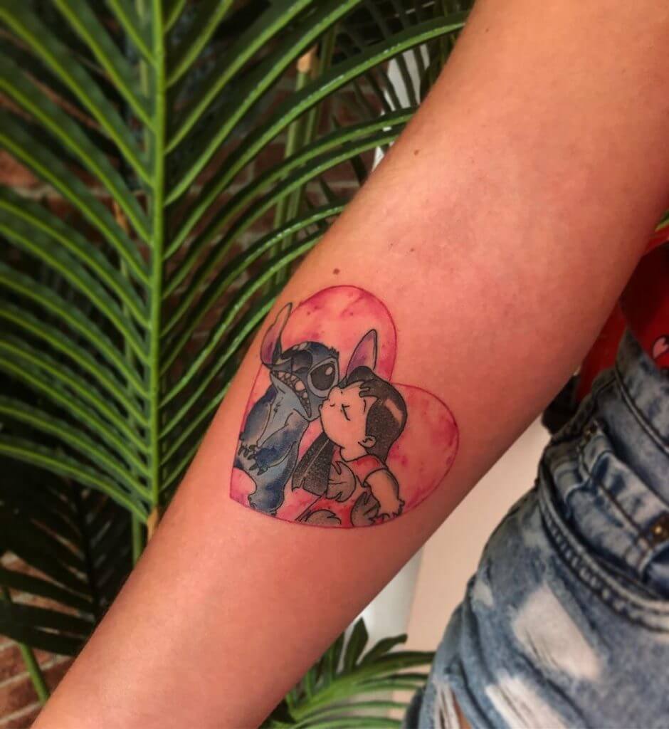 Women color cartoon tattoo of Stitch and Lilo on the right forearm