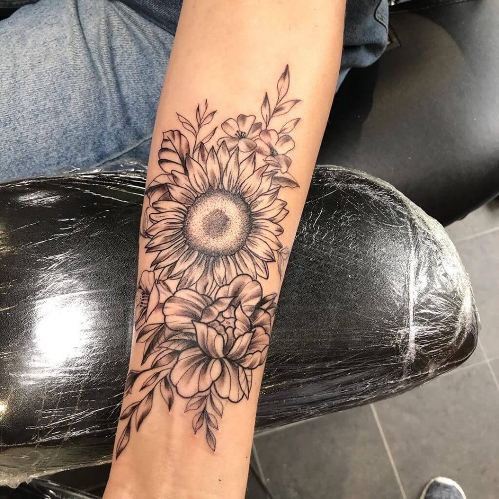 Women black dotwork tattoo of flowers on the left forearm