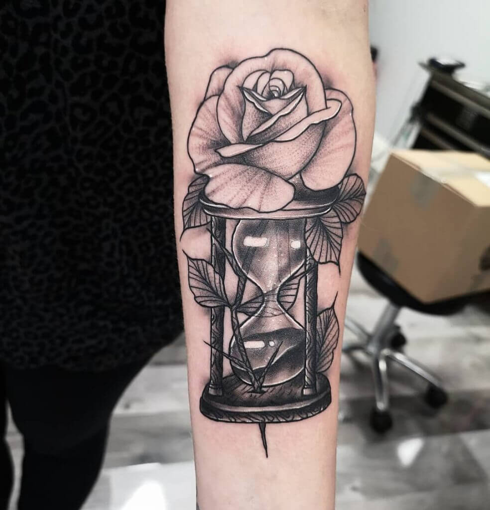 Women black dotwork tattoo of rose with hourglass on the left forearm