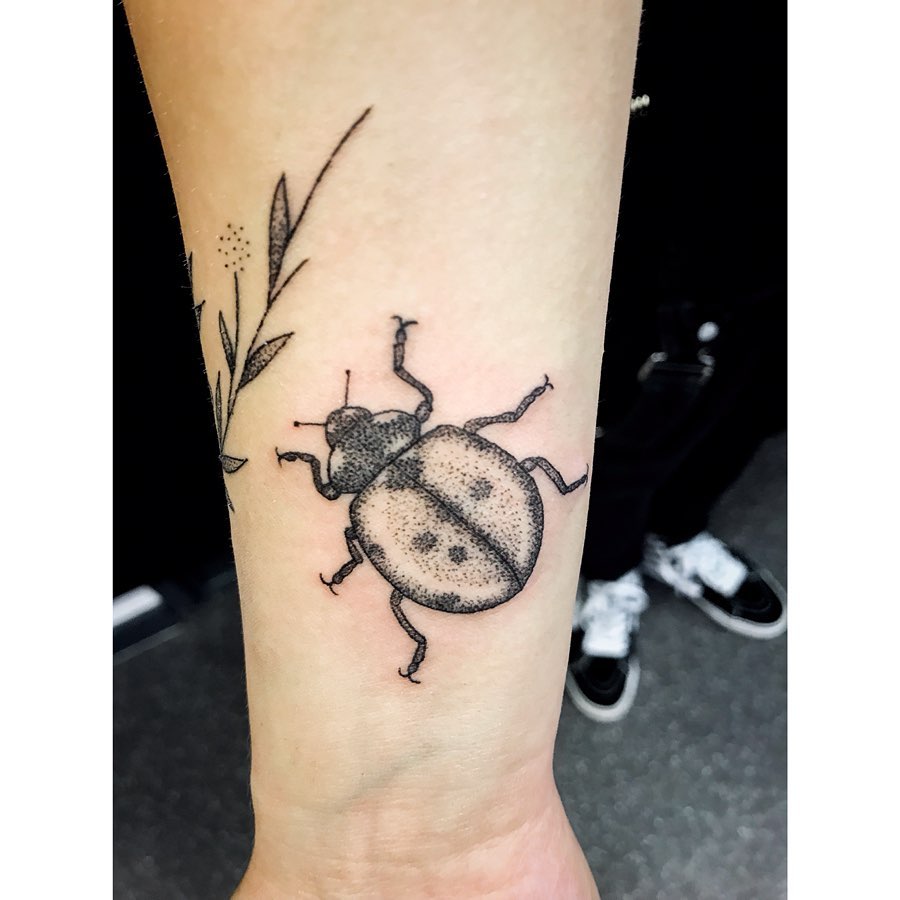Women black dotwork tattoo of a Ladybug on the right forearm