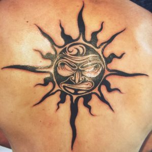 Black sun tattoo on the back