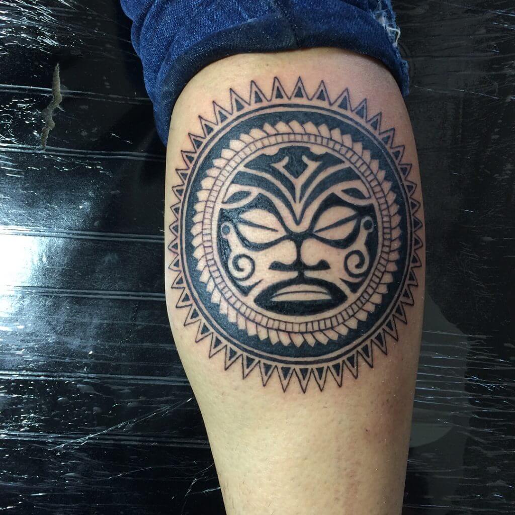 Tribal black sun tattoo on the calf